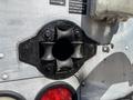 A black circular mounting bracket with four rubber grips is visible on a metal surface, designed to hold a component securely in place