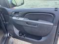 Interior door panel of a 2011 Chevrolet Avalanche featuring a fabric-covered handle and control buttons for windows and locks