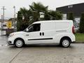 A white 2017 RAM ProMaster City van is parked, featuring sliding side doors and a compact design with round wheels and a simple front grille