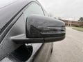Close-up of the side mirror of a 2016 Mercedes-Benz GLA-250 with rain droplets on its surface