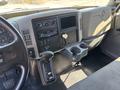 Interior of a 2011 International 4300 with dashboard controls a gear shift and a cup holder visible
