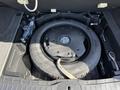 A spare tire is located in the storage compartment of a 2017 Infiniti QX50 with a black rim and tire in a circular shape