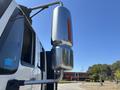 A chrome exhaust stack attached to a white 2011 International 4300 truck with an orange reflector on the side