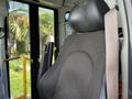 A black fabric driver's seat of a 2020 Chevrolet Express with a seatbelt attached