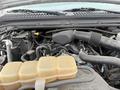 Engine compartment of a 2004 Ford F-350 SD displaying various components including hoses a reservoir and an air intake assembly