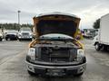A yellow 2014 Ford F-150 with its hood open revealing the engine compartment and front grille