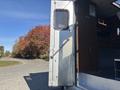 A silver 2008 International 4400 with an open door featuring a metal grate and a handrail inside a vehicle's interior