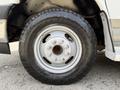Close-up of a wheel on a 2017 Chevrolet Express featuring a silver rim and a rugged tire with the brand name Open Country clearly visible