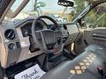 Interior of a 2009 Ford F-450 Super Duty featuring a steering wheel dashboard and seats with a console and controls visible