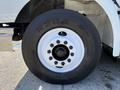 A close-up view of a 2007 International 9200i's wheel featuring a black tire with a white rim and multiple bolt holes