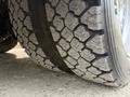 A close-up view of the tread on a tire from a 2012 Ford F-550 showing deep grooves and a rugged design for traction