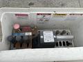 A control panel with various levers and buttons including red and black controls marked for danger and caution signs