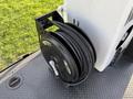 A black hose reel with a coiled hose attached on a flat surface