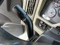 Close-up of a black gear shift lever on the steering column of a 2011 International WorkStar with control markings visible on the side