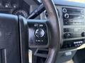 A close-up view of the steering wheel controls of a 2010 Ford F-450 featuring buttons for volume and media navigation