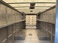 Interior of a 2018 Ford Econoline cargo van showing metal walls and a flat floor with loading steps on each side