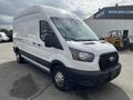 A white 2023 Ford Transit van with a high roof and sliding side door positioned at an angle showcasing its front and side features