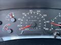 Dashboard of a 2004 Ford F-750 displaying speedometer fuel gauge and engine temperature gauge with readings at 212487 kilometers and a mark for RPM
