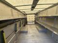 Interior of a 2012 Ford Econoline with metal shelves on either side and a flat floor