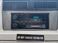Dashboard of a 1994 GMC Vandura 3500 featuring a cassette player radio with various control knobs and a digital clock display showing 12:45