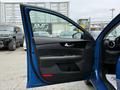 A blue 2021 Kia Forte with the driver's side door open displaying the interior features and controls