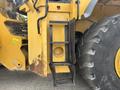 A close-up of the side of a 2012 Caterpillar 980 showing a ladder attached to the chassis near the large tire and other machinery components