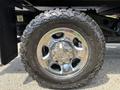 A close-up of a chrome wheel and tire from a 2013 RAM 2500 showcasing its tread pattern and design