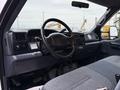 Interior of a 2001 Ford F-350 featuring a black steering wheel gray dashboard and blue patterned seat upholstery