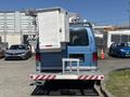 A blue 2008 Ford E-350 van with a mounted equipment compartment and a ladder rack on the back
