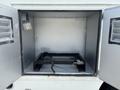 Interior view of a 2011 Workhorse W62 vehicle with a metal storage compartment featuring a black base and a control lever attached to the side