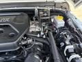 Close-up view of the engine compartment of a 2021 Jeep Wrangler showcasing various components including the engine cover and fluid reservoirs