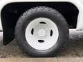 Close-up of a 2017 Ford E450 wheel showing a white rim and a large black tire with rough tread patterns