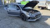 A 2018 Hyundai Sonata with its hood open and front doors ajar showcasing the engine compartment and interior features