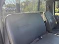 Rear bench seat of a 2004 Ford F-750 with a gray upholstery and a safety belt visible on the left side