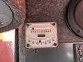 A gauge with a clear display showing measurements and the Sandvik logo on a metallic backing in a machinery control panel