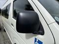 Close-up of the side mirror of a 2009 Toyota Hiace with a blue handicap sticker visible on the door