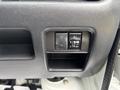 Detail of the interior panel of a 2008 Suzuki Carry showing buttons for lights and a small storage compartment