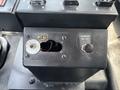 Control panel of a 2015 Ford F-750 featuring various switches and a cannon on/off button with wiring visible in the panel's opening