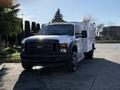 A 2009 Ford F-550 utility truck with a white body and black front grille featuring several lights on top
