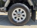 A close-up view of a 2022 Ford F-350 SD tire featuring a chrome wheel rim and rugged all-terrain tread design