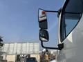 A 2010 Freightliner M2 106 truck featuring a side mirror with an orange light mounted on the cab