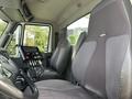 Interior of a 2013 International WorkStar featuring two large seats and a control panel with buttons and levers on the dashboard