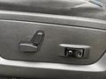 A close-up of the adjustable seat controls on the door panel of a 2018 RAM 1500 including a lever and a button for electronic adjustments