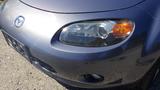 A close-up of a 2007 Mazda Miata's front end showing the headlights and grille design