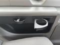 Interior view of a 2013 Ford E-350 Super Duty showing a cup holder and a storage compartment in the front door panel