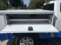 A 2017 Chevrolet Colorado with an open truck bed cover revealing storage compartments and shelves inside