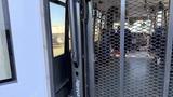 A 2021 Ford Transit interior featuring a wheelchair ramp with a metal frame and a mesh safety barrier