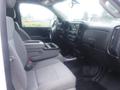 Interior view of a 2015 Chevrolet Silverado 1500 showing gray fabric seats and a console with armrest between the front seats