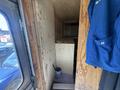A 2009 Workhorse W62 interior showing its wooden framework with a partially installed storage compartment and a blue work hoodie hanging inside