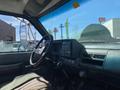 Interior view of a 1996 GMC Top Kick featuring a steering wheel dashboard and gear shift with various controls and dials visible